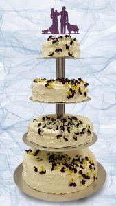 vier stöckige Hochzeitstorte aus Buttercreme mit essbaren Blüten dekoriert