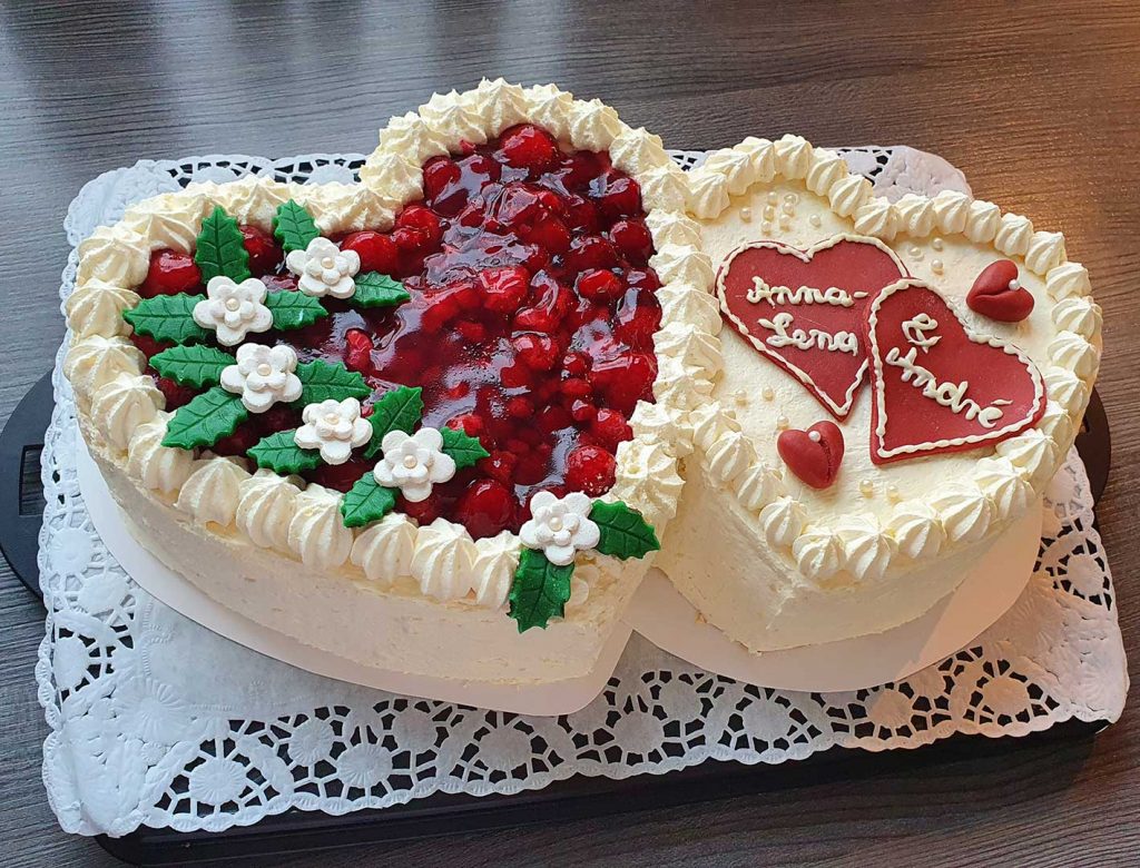 Hochzeitstorte zwei Herzen mit Buttercreme und Himbeeren mit Marzipanblüten
